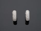 une paire de boucles d'oreilles créoles en or blanc et diamants