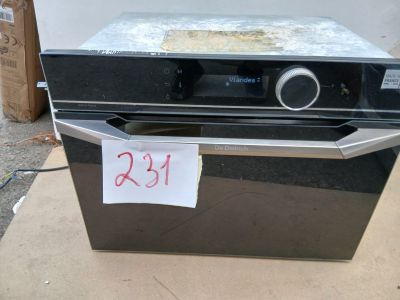 un four noir posé sur une boîte en carton sur laquelle est collée une étiquette de prix