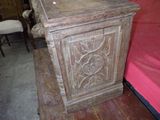 a small wooden cabinet with a carved design on it