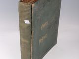 un livre vert ouvert sur une surface blanche
