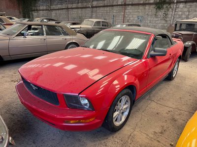 une Mustang rouge garée sur un parking avec d'autres voitures