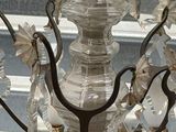 a glass chandelier with a bird perched on top of it
