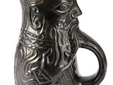 une tasse noire avec un visage dessiné dessus, sur fond blanc