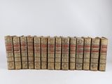 six vieux livres alignés sur une surface blanche