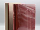 un livre ouvert à couverture rouge posé sur une table blanche