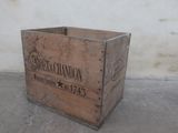 a wooden crate sitting on the floor in front of a wall