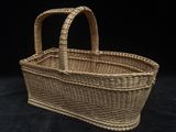 a small wicker basket with handles on a black background