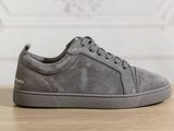 a close up of a pair of grey sneakers on a wooden table