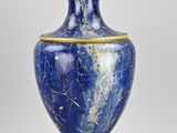 une image représentant un vase bleu et or sur lequel est posée une lampe