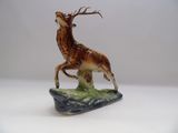 une figurine représentant un cerf debout sur un rocher