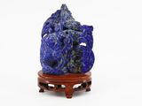 a close up of a blue stone sculpture on a wooden stand