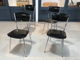 quatre chaises qui sont assises ensemble dans une pièce