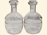 une paire de carafes en verre transparent, munies chacune d'un bouchon