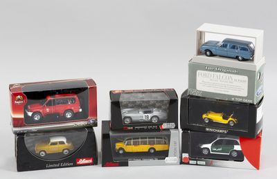 quatre modèles différents de voitures dans des boîtes, posés sur une surface blanche