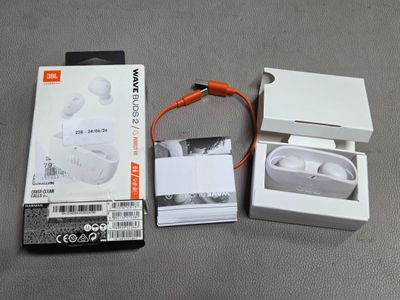 une boîte blanche avec un écouteur orange et une boîte blanche avec un écouteur orange