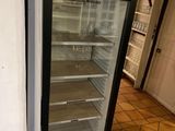 un réfrigérateur vide dans une cuisine au sol carrelé