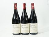 trois bouteilles de vin rouge posées sur une table blanche
