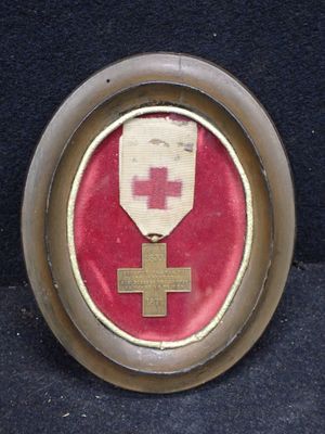 une photo d'une médaille sur laquelle figure une croix rouge