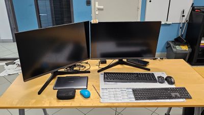 un bureau sur lequel sont posés deux écrans d'ordinateur et un clavier