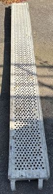 a long metal grate on the ground next to a building