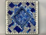 a close up of a blue and white mosaic tile on a wall