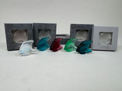 four small glass fish figurines sitting in a box