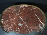 a red marble table with a gold rim on it