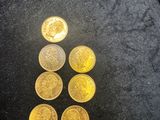 a pile of gold coins sitting on top of a black surface