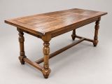 une vieille table en bois avec des pieds tournés et un plateau en bois