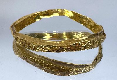 bracelet rigide plaqué or, au motif incurvé sur fond blanc