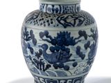 a blue and white vase sitting on a white surface