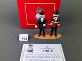two figurines of two men dressed in suits and ties