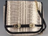 a white and black snake skin purse with gold hardware