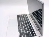 a white laptop with a black keyboard on a white surface