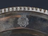 a silver plate with a crest on it