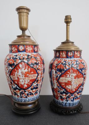 une paire de vases asiatiques posés sur un socle, surmontés de lampes