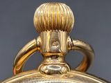 a close up of a gold plated clock on a table