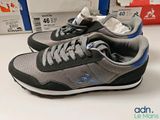 pair of grey and blue running shoes sitting on top of a table