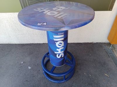 un tabouret bleu sur lequel est posée une bouteille de bière
