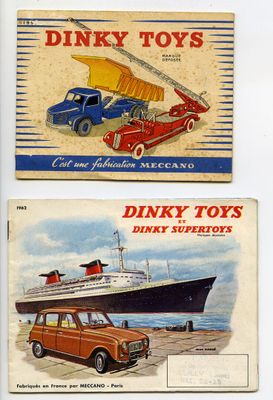 Deux boîtes de Dinky Toys sont posées sur une surface blanche