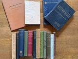Plusieurs livres sont empilés les uns à côté des autres sur une table en bois.