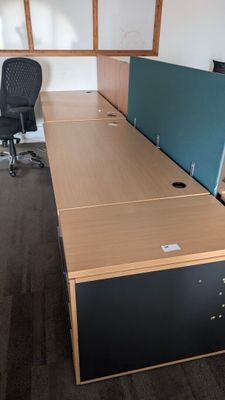 a desk with a chair and a monitor in an office