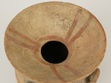 a brown vase with a hole in it on a white surface