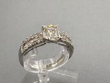 une photo d'une bague en diamant posée sur un socle transparent