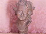 a small statue of a child with curly hair on a table