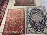Plusieurs tapis sont disposés sur le sol carrelé d'une pièce