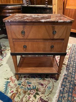 a small wooden table with a marble top on a rug