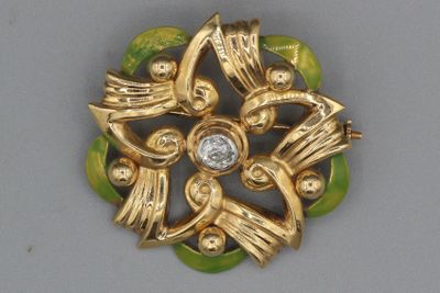 une broche en or ornée d'un diamant au centre