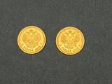 deux pièces d'or posées sur une surface noire