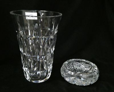 a glass vase and a glass ashtray on a black background